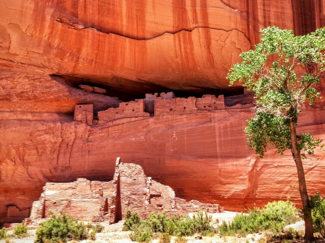Ancient ruins along the side of a red rock cliff in Canyon de Chelly National Monument, Arizona