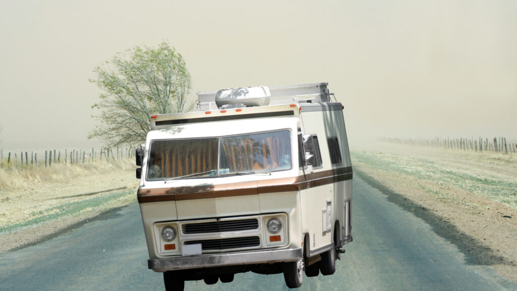 An RV swerves on a windy stormy road.