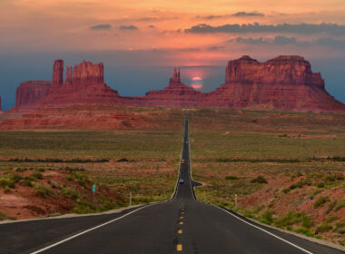 A sunset over Monument Valley with wide open roads.