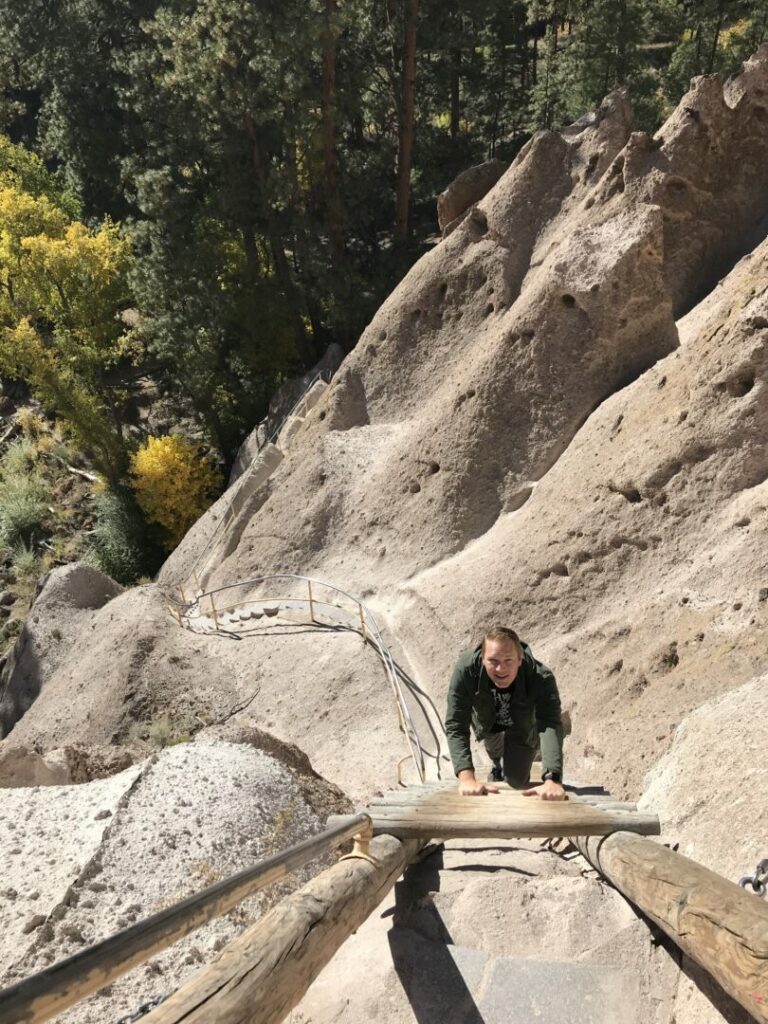 Getaway Couple Jason Miller climbs up the ladder leading into the Bandelier National Monument.