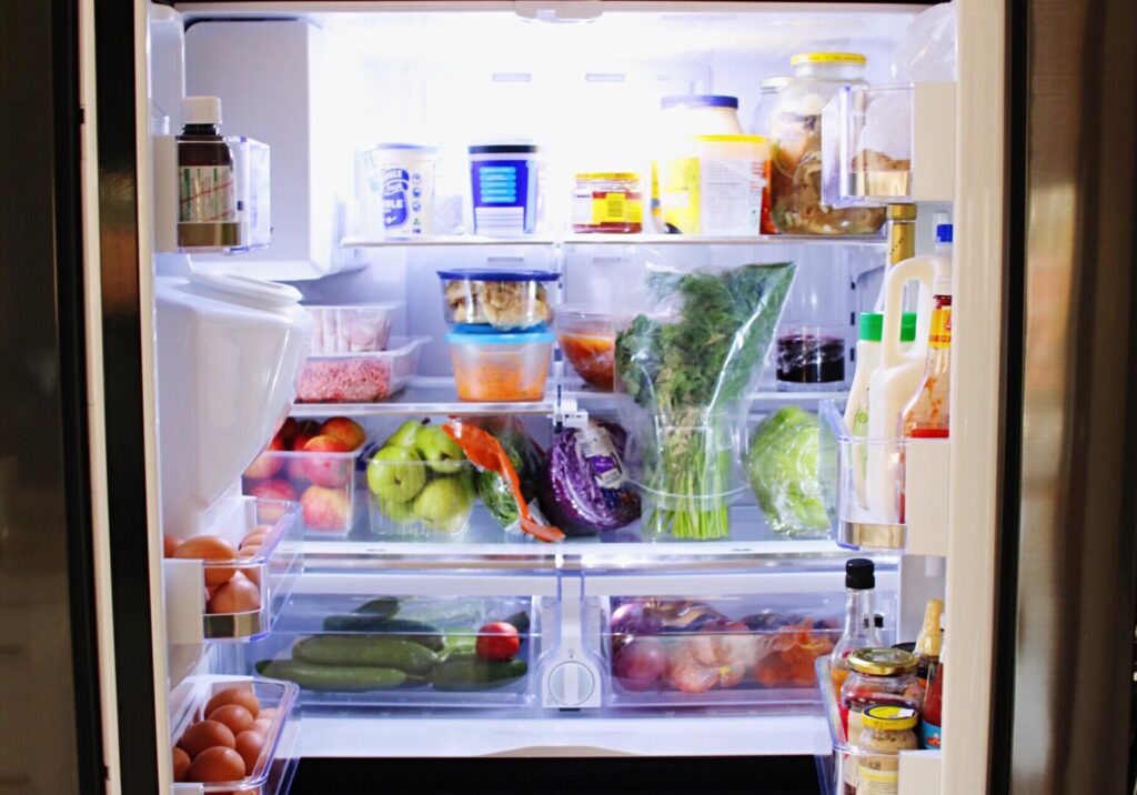 A fully stocked fridge with lots of healthy and colorful food.