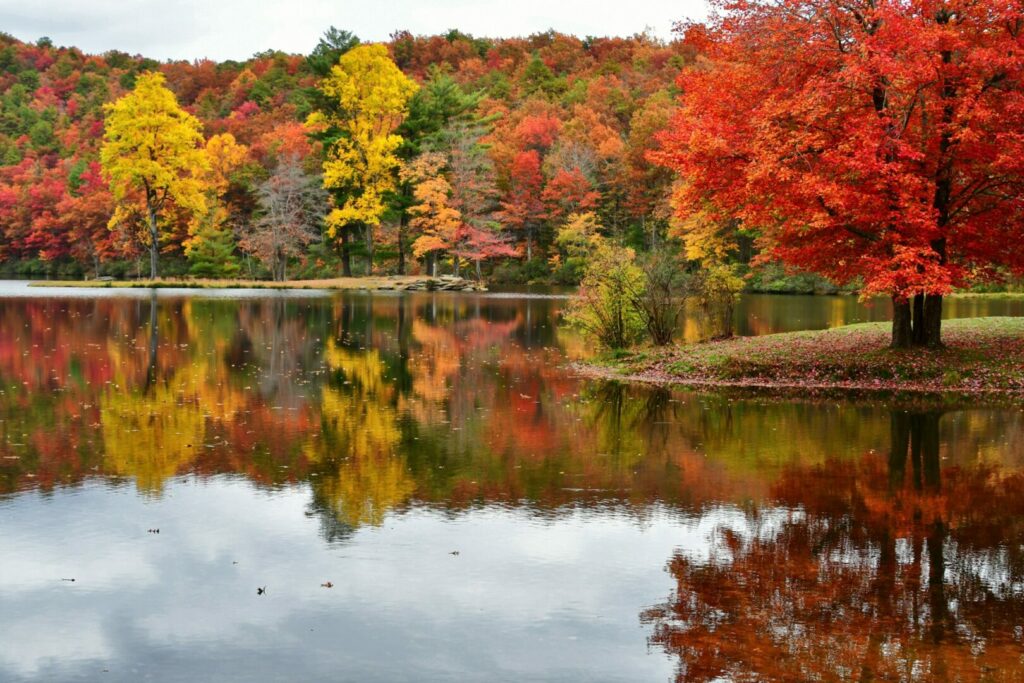 Colorful fall foliage reflecting in a mountain lake in Virginia. Sherando Lake Shenandoah Valley Blue Ridge Mountains.