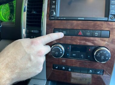 A hand reaches to turn on Tow Haul mode from a dashboard button in the truck.