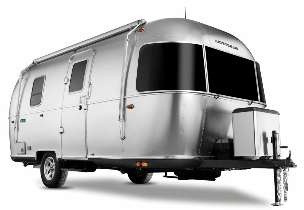 An isolation of a shining metallic Airstream Bambi travel trailer on white.