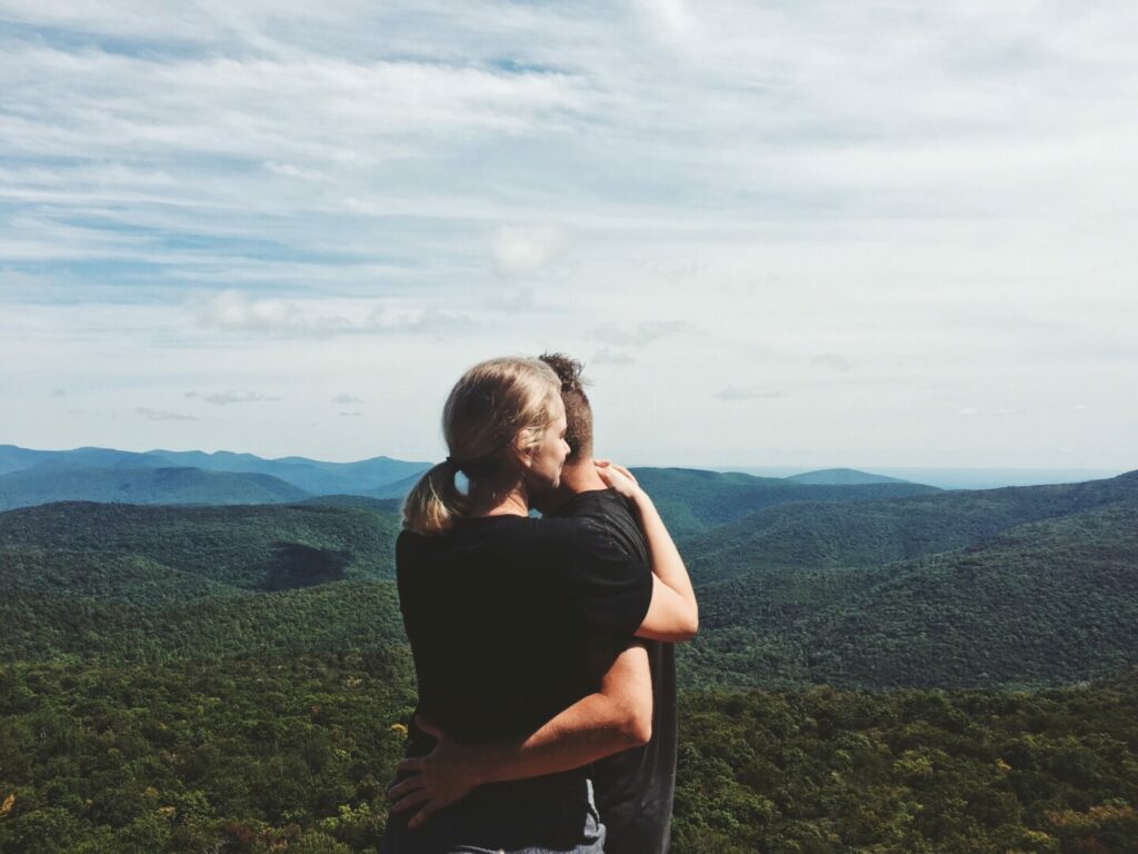 Couple hugging at the top of a mountain in New York State Park.