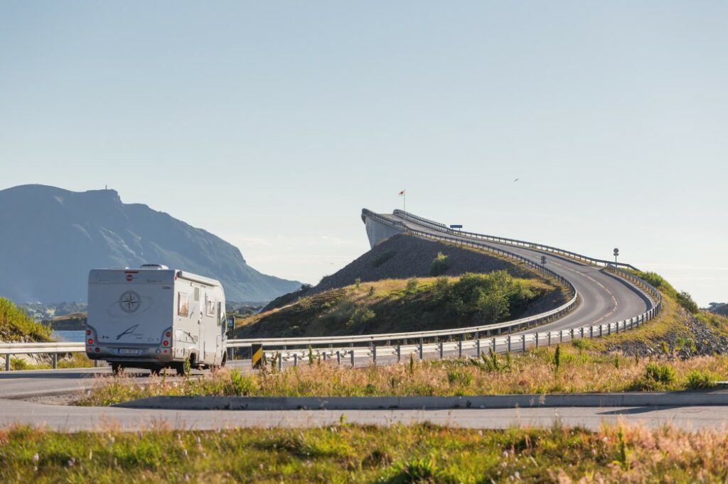 A camper is on a road trip down an interstate and heading towards a bridge.