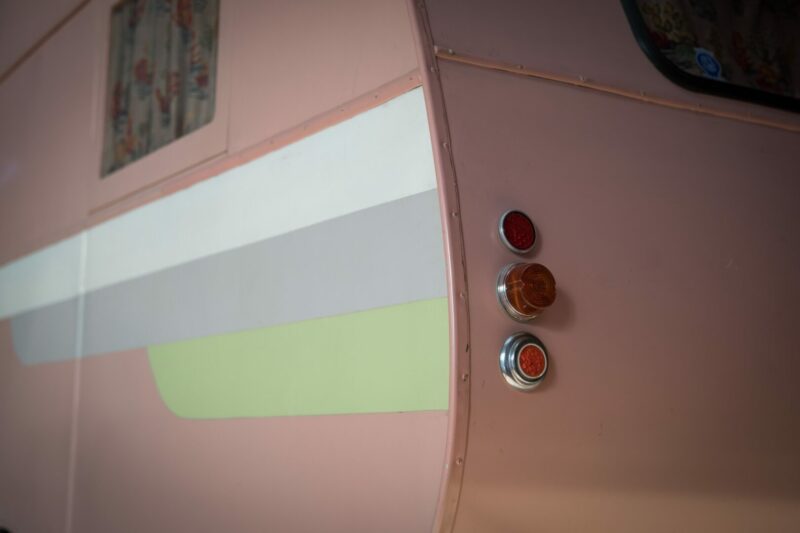 A pink rv with custom painted decals to replace the old faded decals.