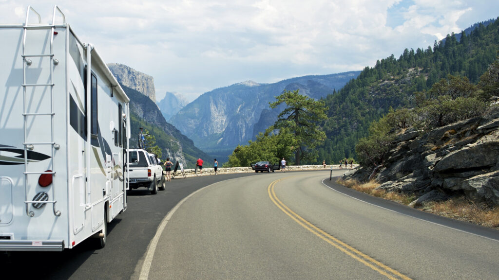 An RV is pulled of at the picturesque scene of Yosemite Valley. 