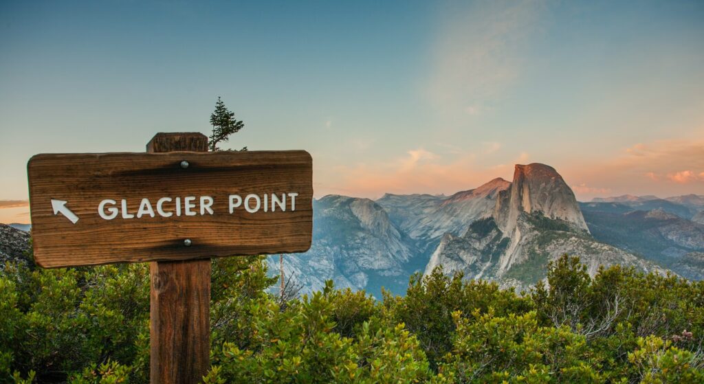 A wooden sign directing a hiker to Glacier Point in Yosemite National Park in California.