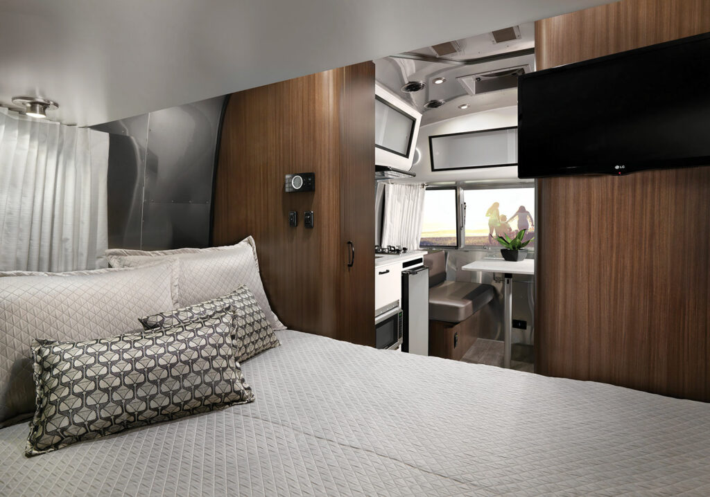 Interior view of a 2022 Airstream Caravel from the sleeping quarters looking in towards the kitchen.