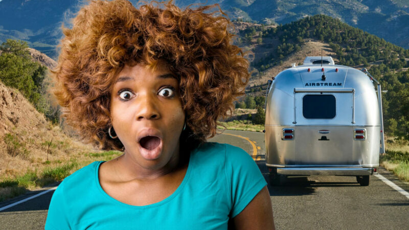 A woman's eyes are wide and mouth is ajar in shock at the price of an Airstream