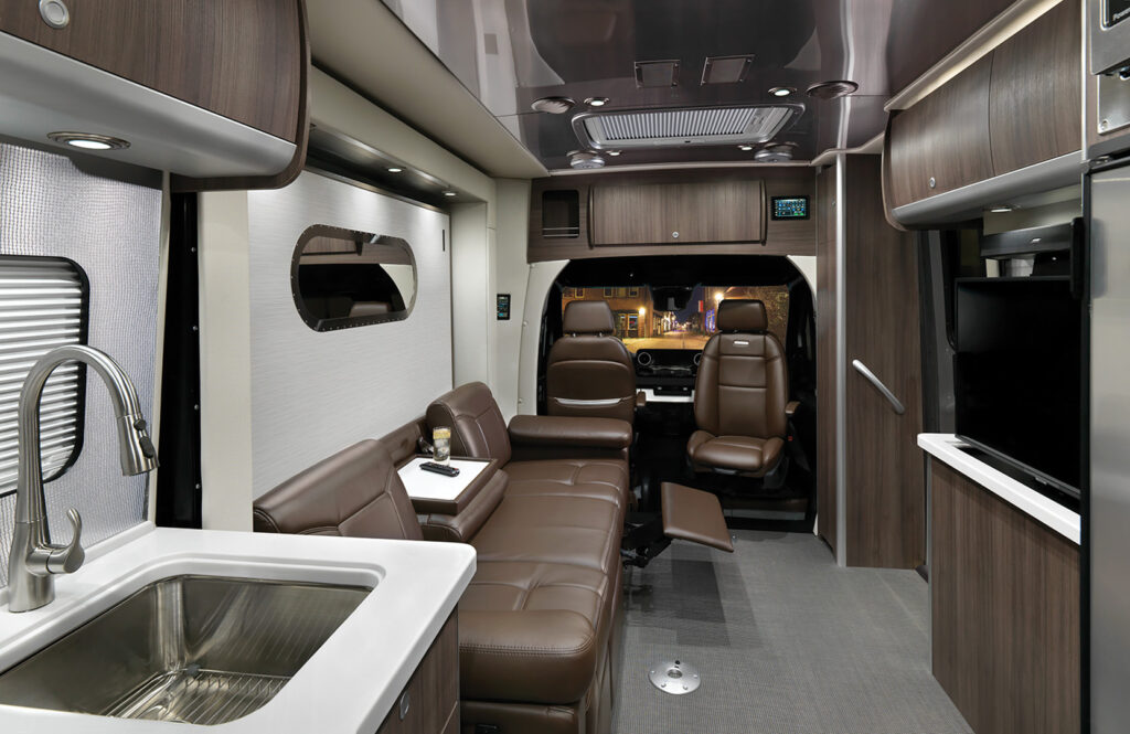 Interior of the Airstream Atlas Touring Coach with brown leather finishings and a reclining couch