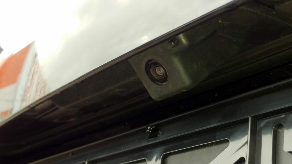 Closeup of a black rear view backup camera mounted on the back of a vehicle