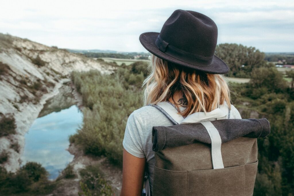 A woman hikes out in the wilderness with her har and backpack