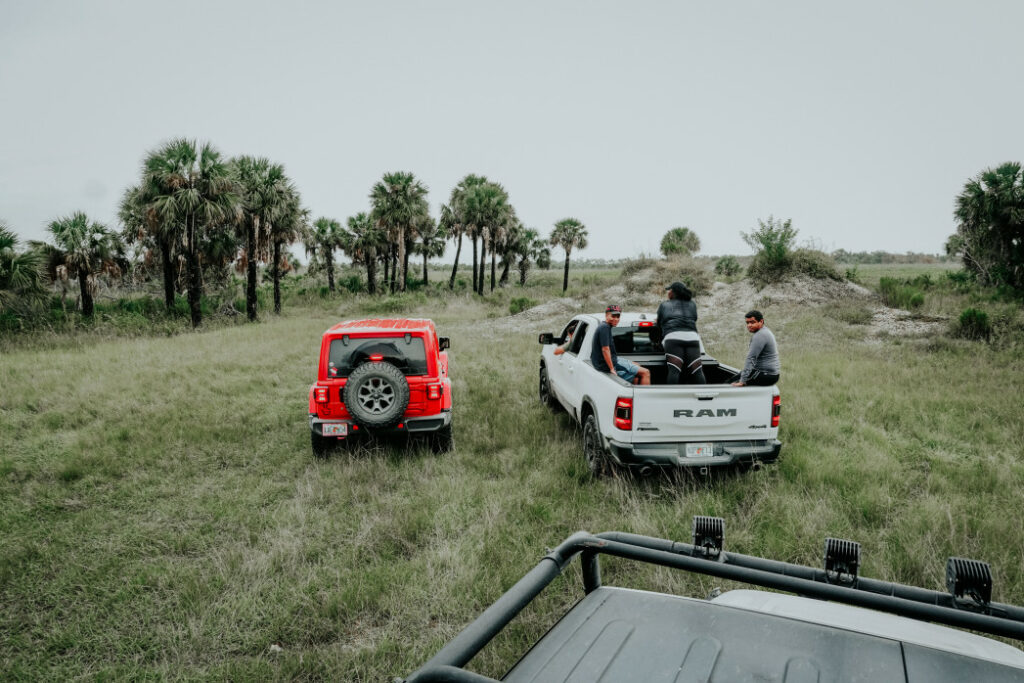 Friends in the back of a Ram truck bed off-roading in Florida