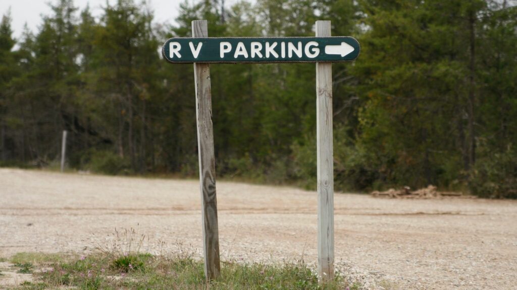 A wooden sign designates where RV parking is at a campground.