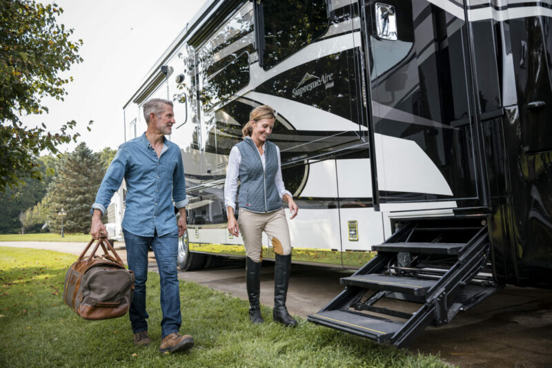 A couple walks up to the steps of their Newmar RV after a day of horse back riding