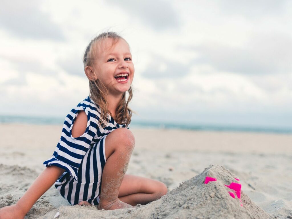 Girl happily playing on seashore