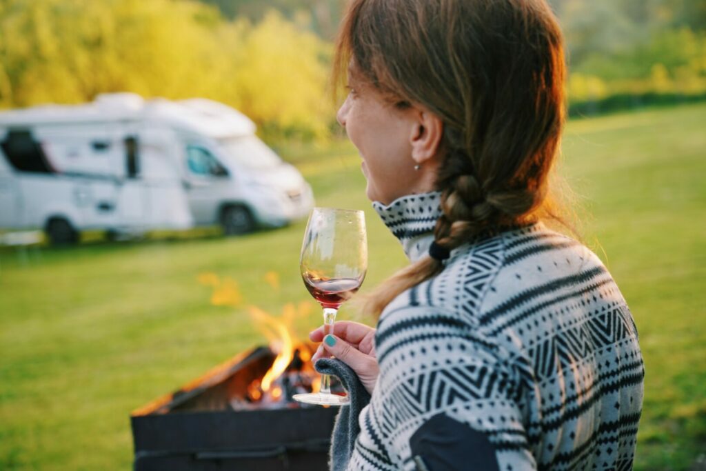 Woman drinking wine in front of the RV