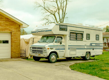 Motorhome parked on a camper pad in a driveway.