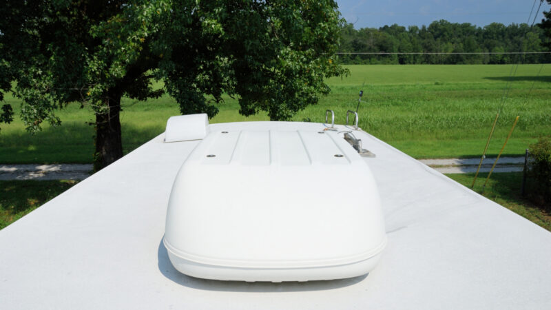 A rooftop Coleman RV Air Conditioning unit shines bright white on a clean white rv roof.