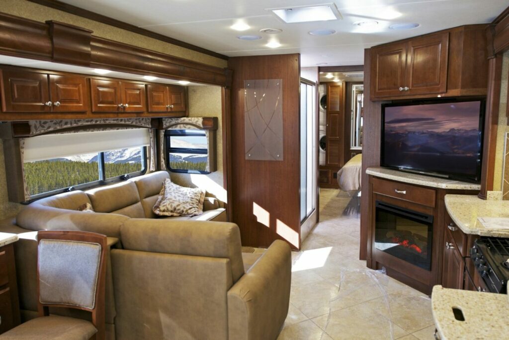 A modern RV interior with a fireplace in the living room area.