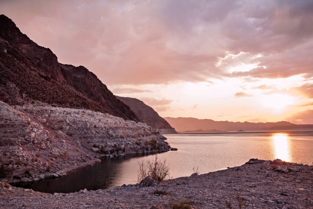 A view of Lake Mead with the sun setting over the mountains.