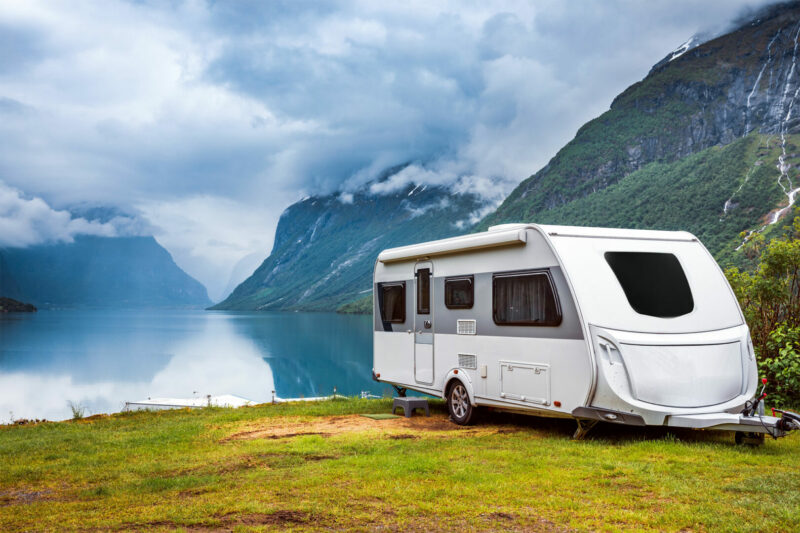 Travel trailer next to a beautiful lake in the mountains