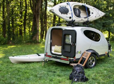 A small MyPod travel trailer with a kayak mounted on top
