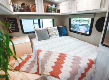 A modern camper decorated with cute blankets, plants, and pillows.