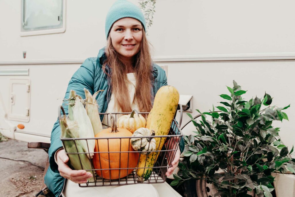 Middle aged woman holds a basket of fresh produce she has brought back home to her RV