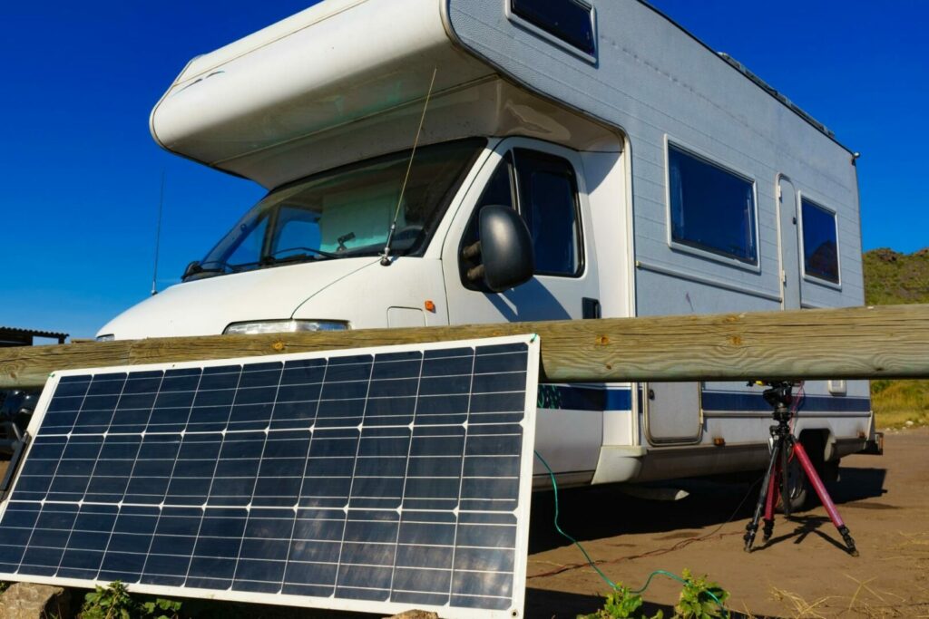 A portable solar panel set up outside of a motorhome for creating power.