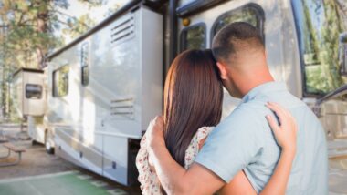 A couple hugs and looks towards a new, reliable RV they plan to purchase