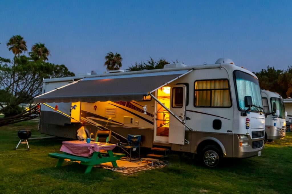 An RV lit up under the night sky uses power from it's batteries for the indoor lights