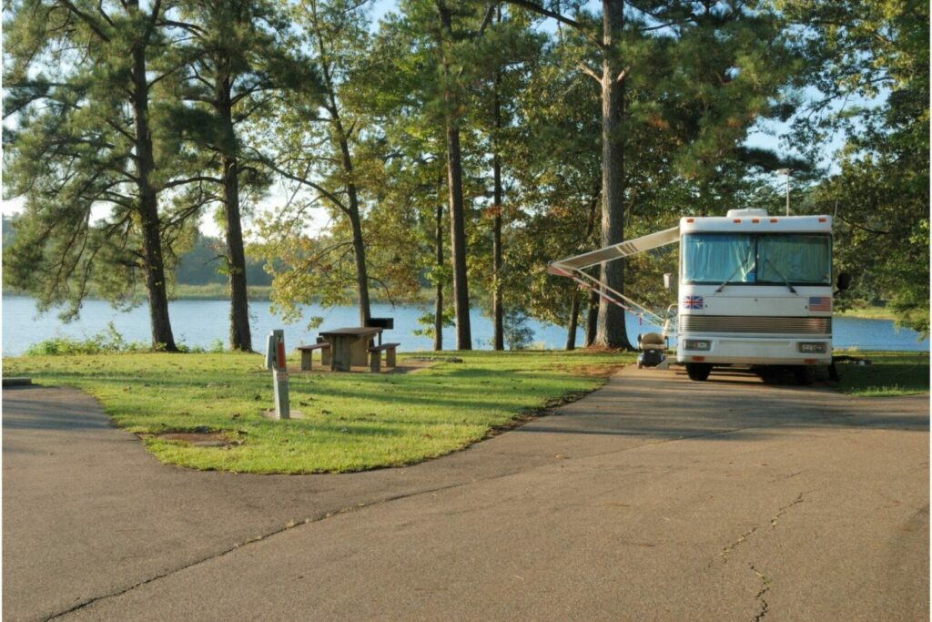 A motorhome camping by a lake in the summer.