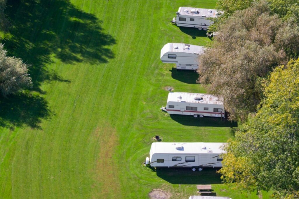 Aerial view of a row of budget travel trailers at an RV park.