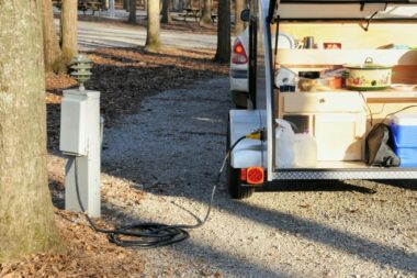 Travel trailed plugged in to a campground electrical pedestal.
