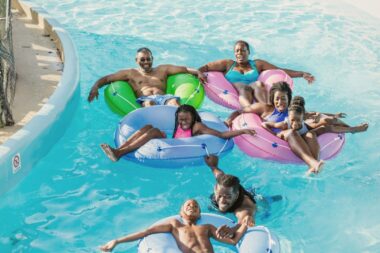 A multigenerational family laughs as they tube down a lazy river together