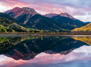 A colorful sunrise over the mountains and a lake in the valley in Colorado