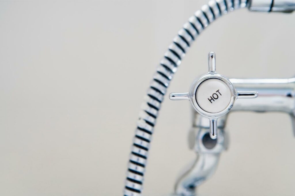 Close up of the hot water nozzle on a shower faucet