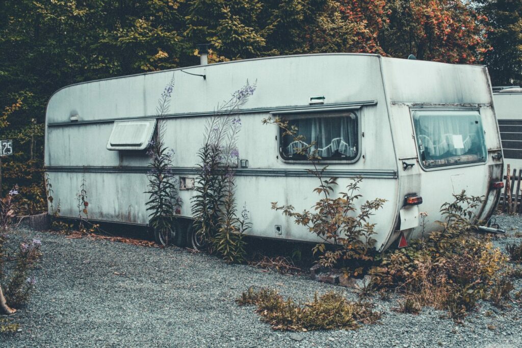 A dirty, worn down RV shows wear from not being put in covered storage during the off-season.