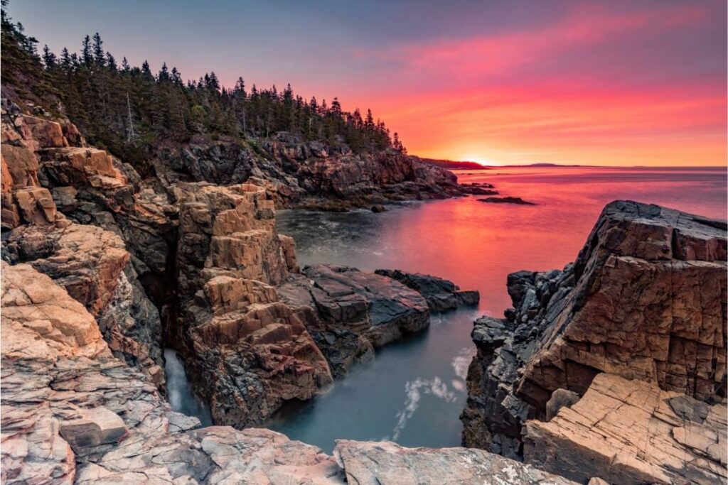 A stunning, colorful sunset over the coastline in Acadia National Park.
