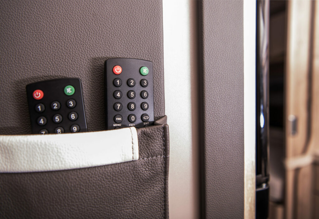 Two remotes sitting in the back pocket of a travel trailer for the RV entertainment system