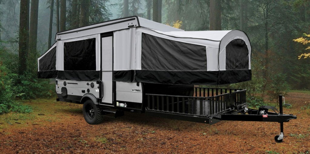 A Coachmen RV Pop up camper set up in the woods
