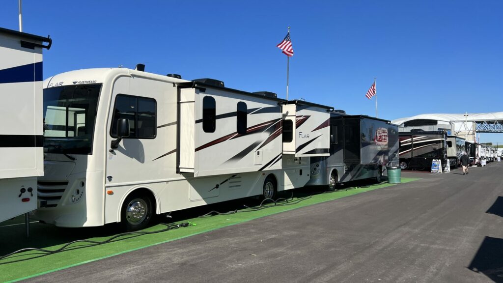 A variety of show model RVs at an RV show at a dealership.