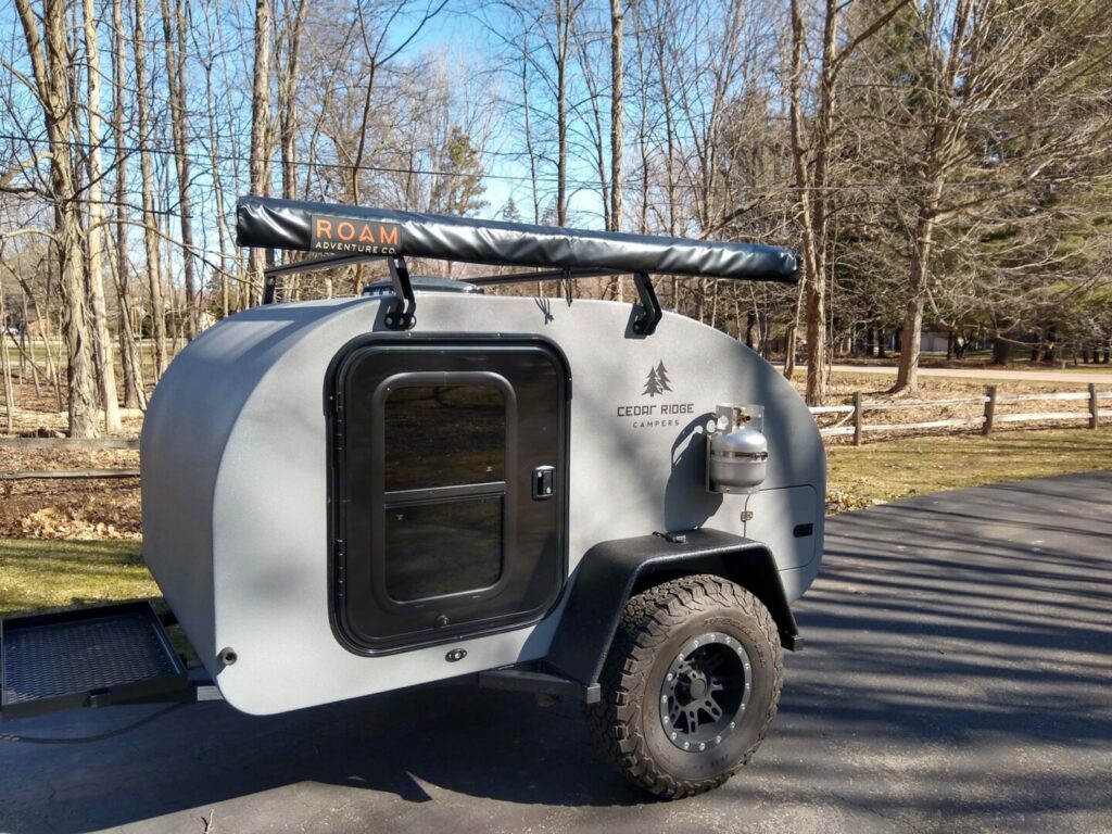 A small teardrop trailer parked in a campsite
