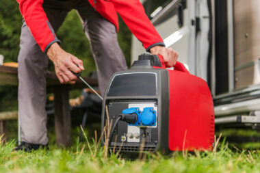 A man turning on his quiet, portable gas powered generator for his RV.