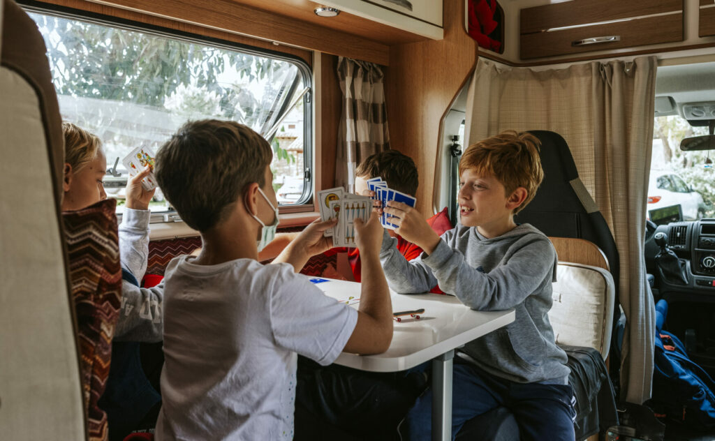Four young kids playing cards in an RV 