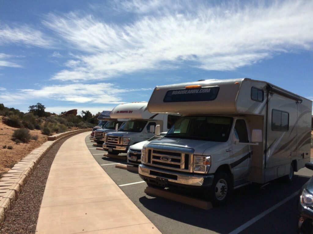 Multiple RVs parked next to each other outside a dealership. Try National Indoor RV Center for your next purchase.