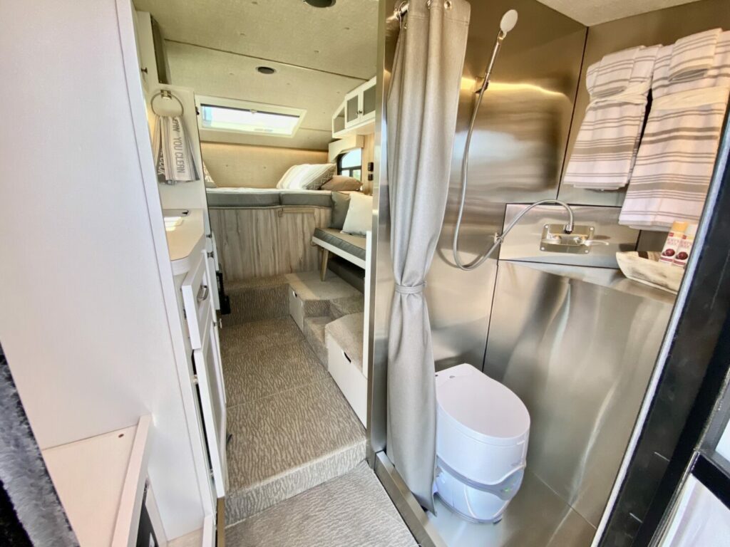 A glimpse inside a Kingstar camper, showcasing the bathroom, bedroom, and kitchen area.
